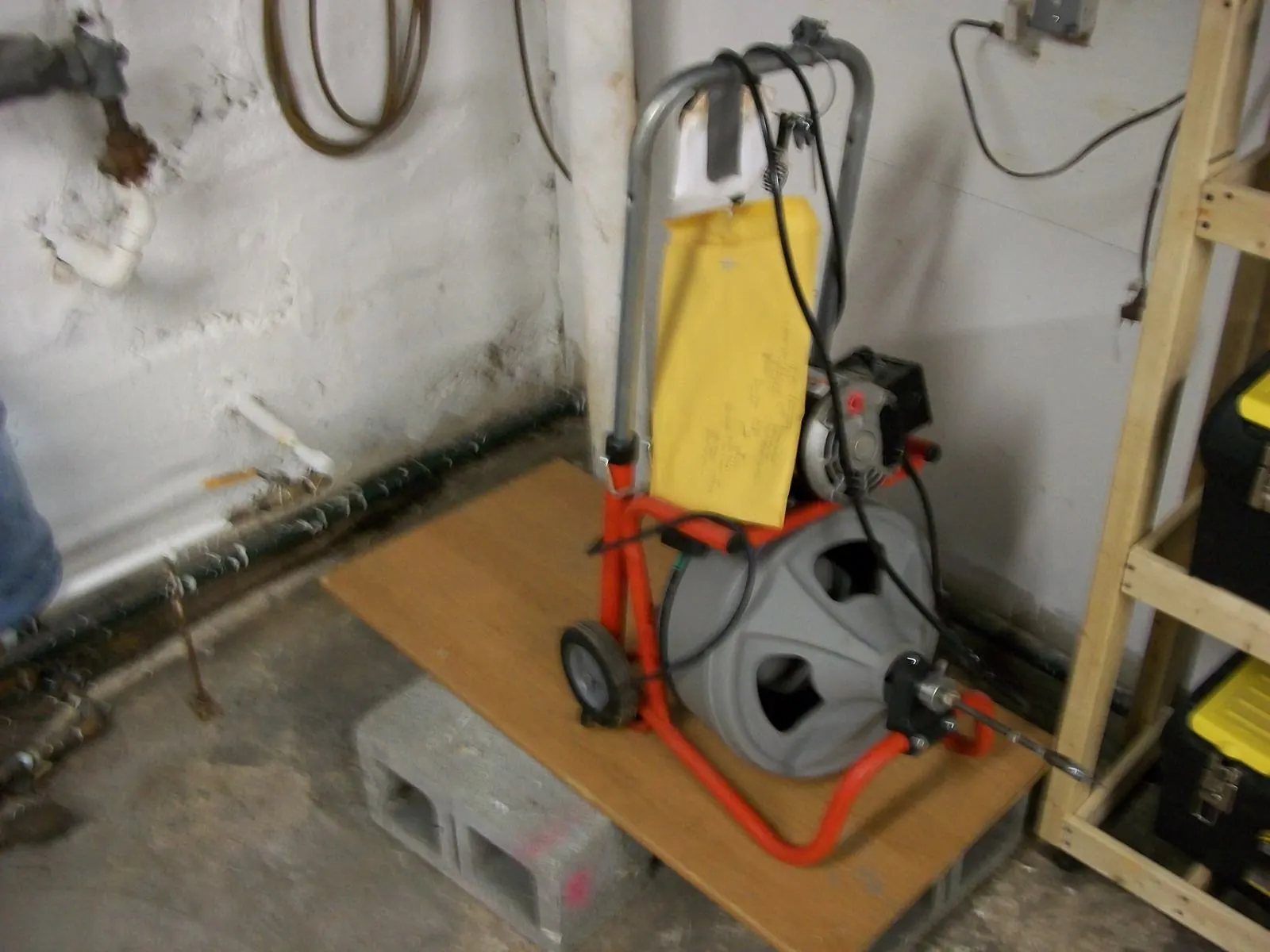 Máquina desatascadora de tambor con espiral metálica preparada en un garaje