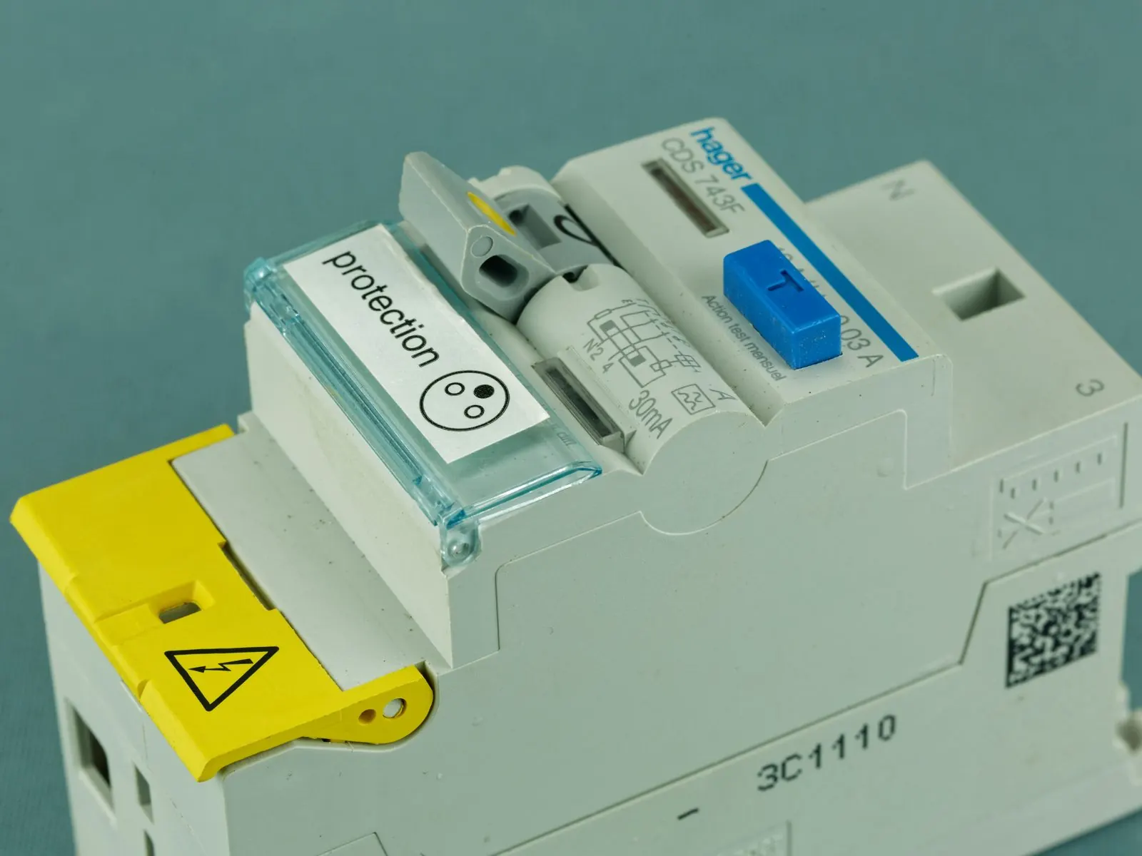 Primer plano de un interruptor diferencial modular con tapa transparente y etiqueta de protección
