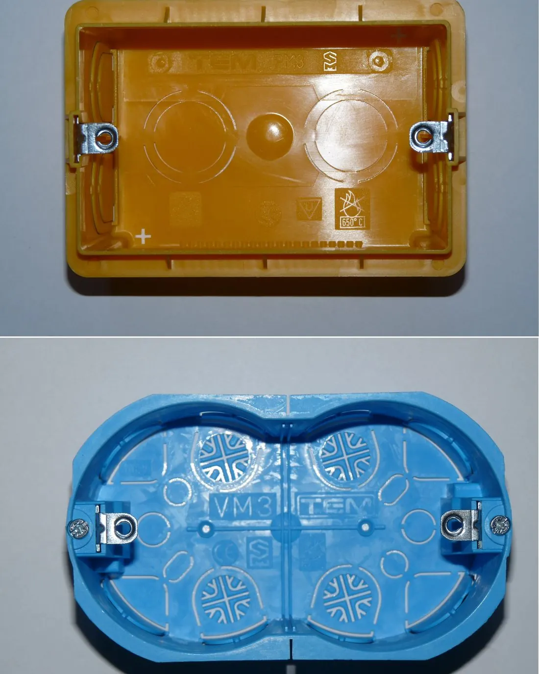 Dos cajas de mecanismo empotrables, una naranja rectangular y una azul doble