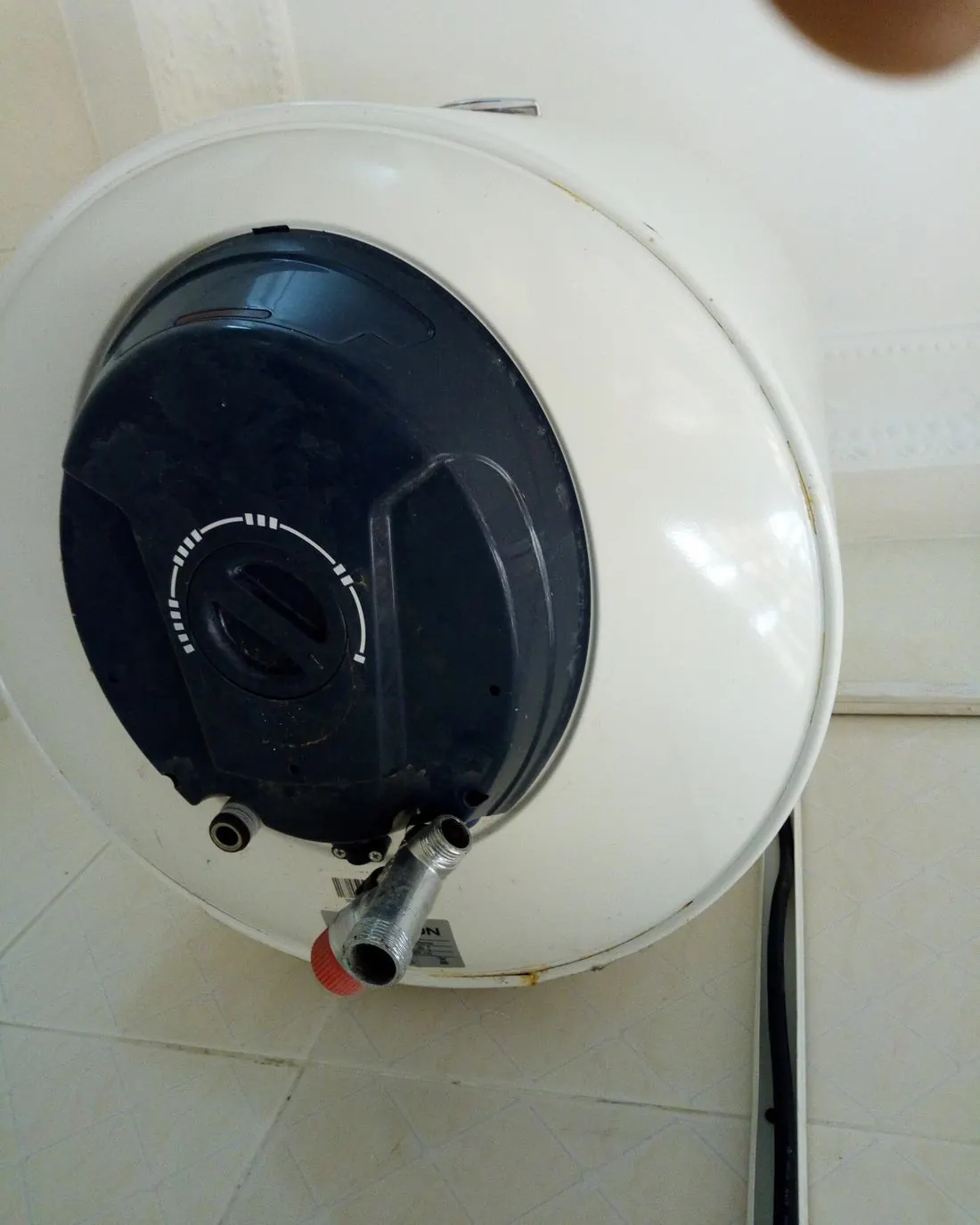 Termo eléctrico de 50 litros colgado en la pared con su válvula y conexiones abajo